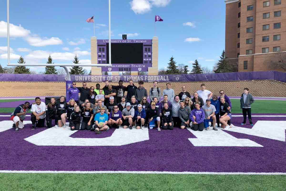 Students posing for a photo at the football field