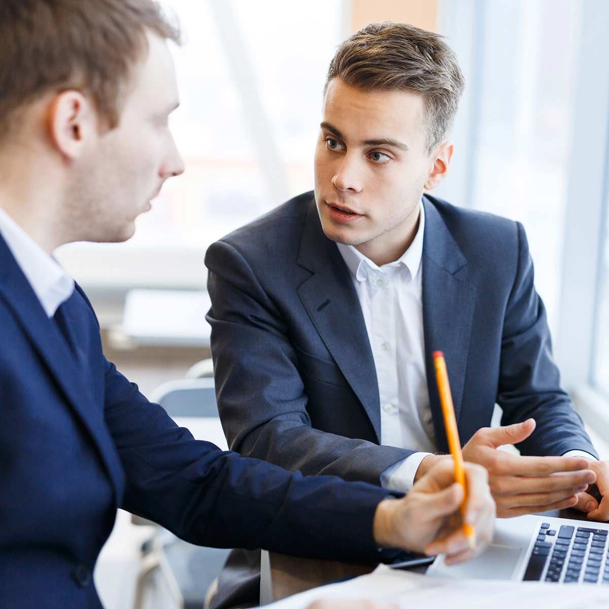 Two men in suits, talking.